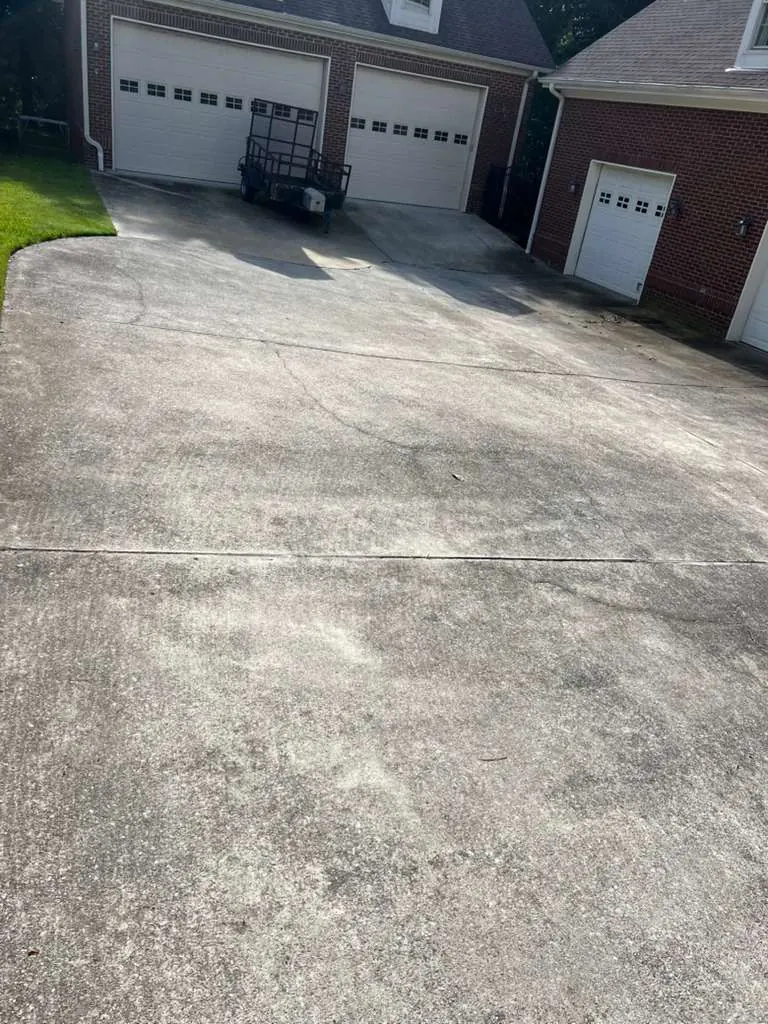 Gray, algae-stained concrete driveway before pressure washing
